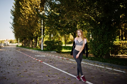 Young girl has the training and doing exercise outdoors. Sport, fitness, street workout concept. photo