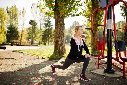 Young girl has the training and doing exercise outdoors on street simulators. Sport, fitness, street workout concept. photo
