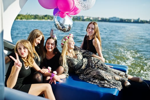 Five girls wear on black having fun at yacht against lake at hen party. photo
