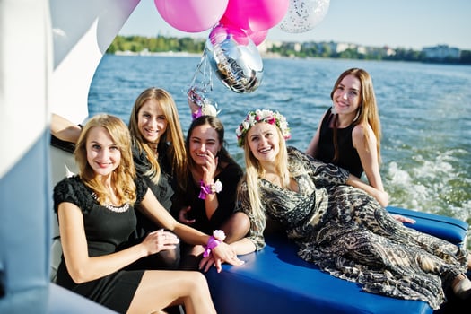 Five girls wear on black having fun at yacht against lake at hen party. photo