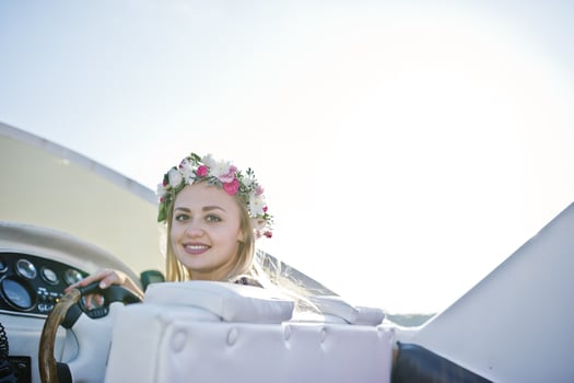 Blonde girl in wreath sitting on yacht at hen party. photo