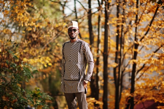 Portrait of stylish black african american man at hat and sunglasses against sunny autumn fall background. photo