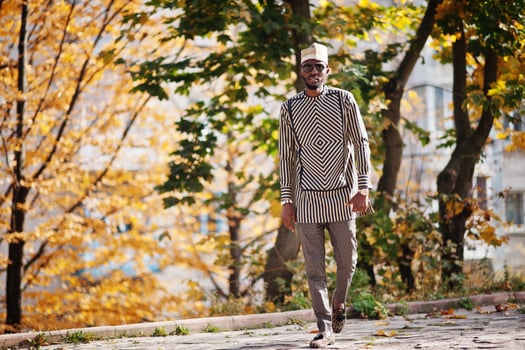 Portrait of stylish black african american man at hat and sunglasses against sunny autumn fall background. photo