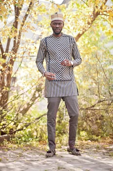 Portrait of stylish black african american man at hat against sunny autumn fall background. photo