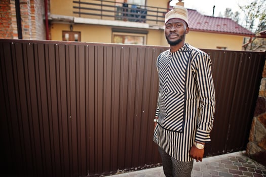 Portrait of stylish black african american man at hat and sunglasses against fence. photo