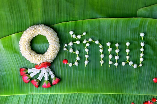 Thai traditional jasmine garland. symbol of Mother's day in thailand on Banana leaf with Love Mother in Thai word. photo
