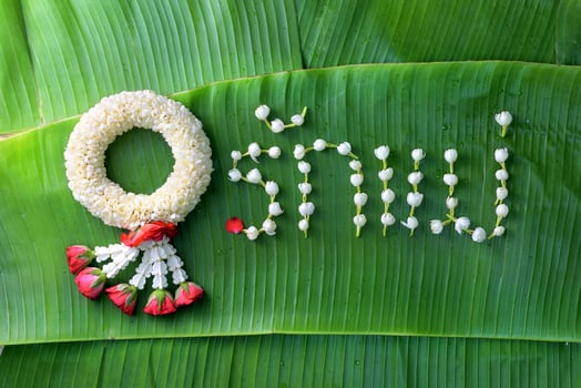 Thai traditional jasmine garland. symbol of Mother's day in thailand on Banana leaf with Love Mother in Thai word. photo