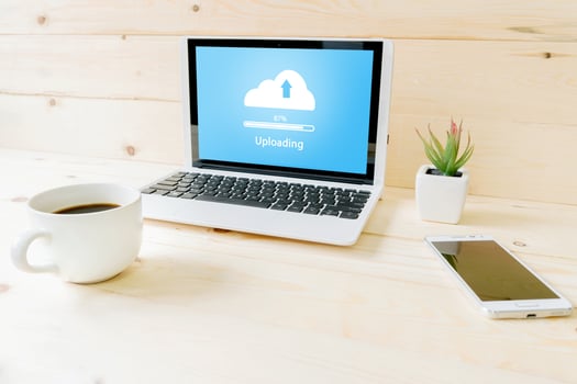 Cloud uoloading on laptop  on wood table photo