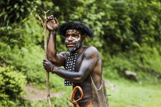 Portrait of Dani Tribe man wearing koteka, traditional clothes of Papua. Dani tribe men ready to hunt animal prey in the jungle. photo