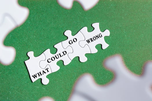 What could go wrong text on white jigsaw puzzle with some missing pieces. photo