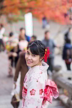 young woman tourist wearing kimono enjoying with colorful leaves in Kiyomizu dera temple, Kyoto, Japan. Asian girl with hair style in traditional Japanese clothes in Autumn foliage season photo