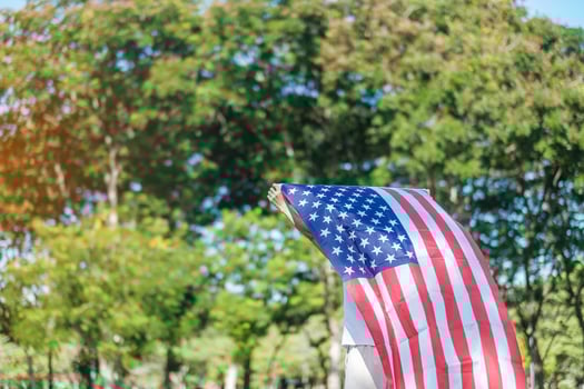 Woman traveling with United States of America flag in park outdoor. USA holiday of Veterans, Memorial, Independence and Labor Day concept photo