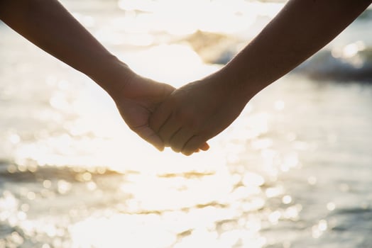 Asian couple is holding hand near to the sea photo