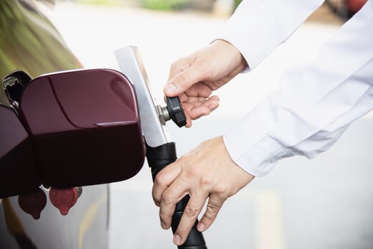Man is putting NGV, Natural Gas Vehicle, head dispenser to a car at the gasoline station in Thailand photo