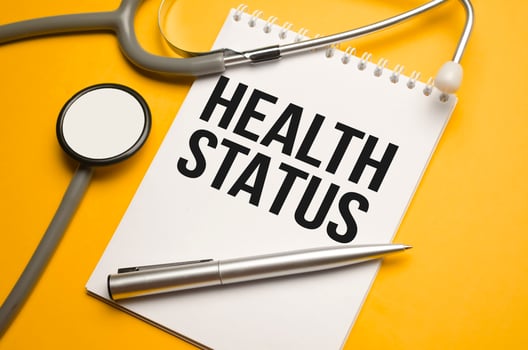 In the notebook is the text Health Status stethoscope, pills, and glasses photo