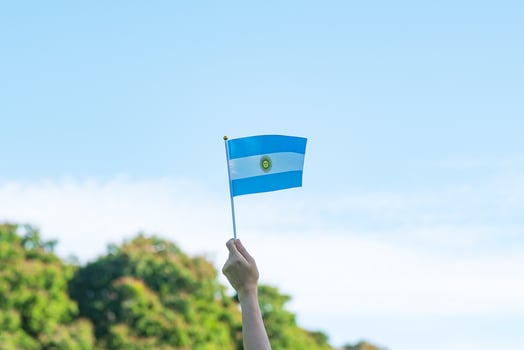 hand holding Argentina flag on nature background. 9th July of Independence day, 25th May of Revolution day and happy celebration concepts photo