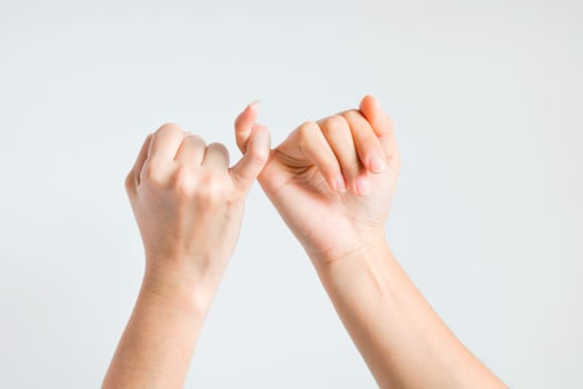 Two hands hook little finger together. photo