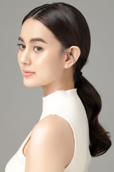 Beautiful young Asian woman model with perfect clean fresh skin on grey background. Face care, Facial treatment, Cosmetology, Plastic Surgery, Lovely girl portrait in studio. photo