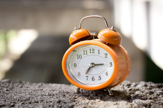 Orange vintage style alarm clock in an abandoned unfinished building. photo