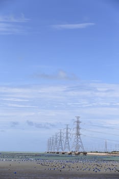 High voltage power pole in the sea photo