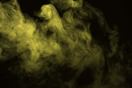 Abstract golden smoke isolated on black background photo