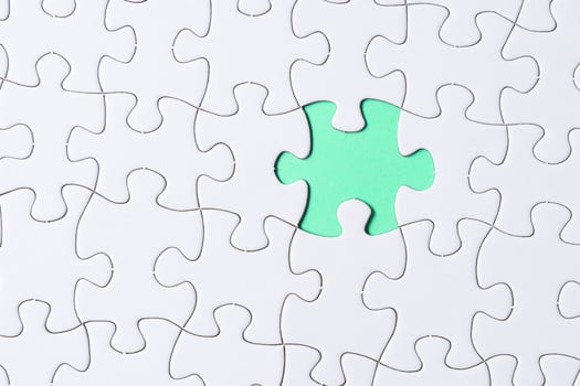 Piece of jigsaw puzzle on green paper. Flat lay, Directly above. photo