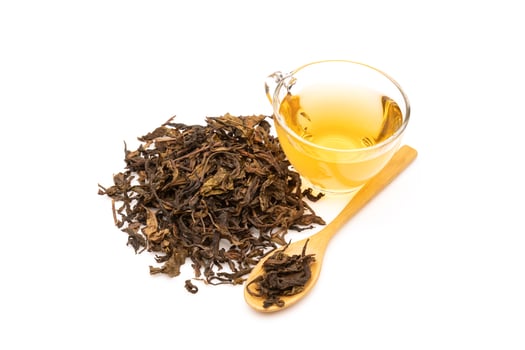 Cup of hot tea and tea leaf isolated on white photo