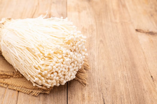 Golden needle mushroom on wooden table background. Food and healthcare concept photo