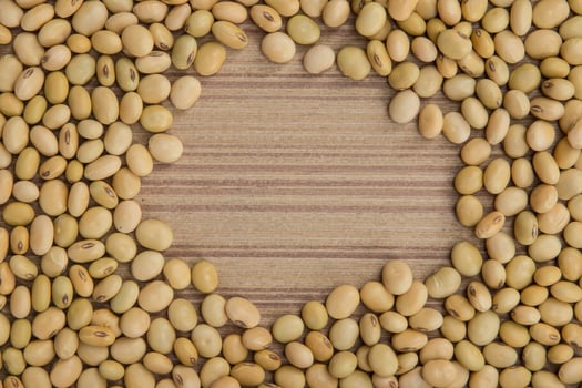 Dry soybeans on wooden board photo
