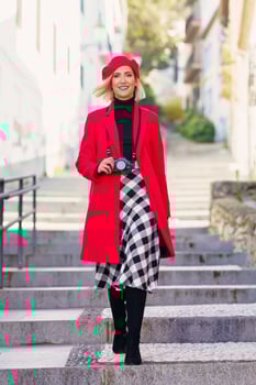 Happy elegant lady walking downstairs on town street and smiling photo