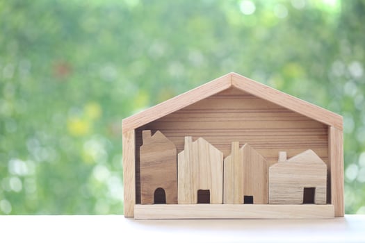 Small house in big house on natural green background, Business investment and real estate concept photo