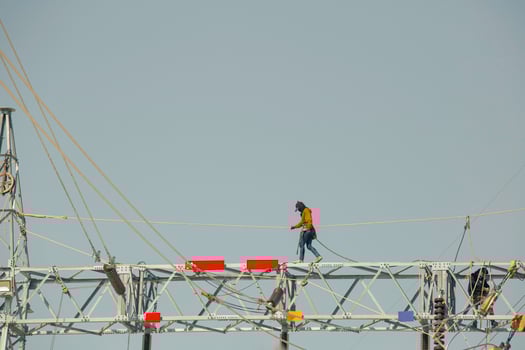 Male walking on the beam steel Installation of high-voltage  transmission electricity poles photo