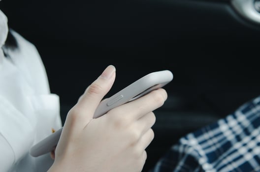 close up woman hand holding a mobile phone in the car cabin. photo