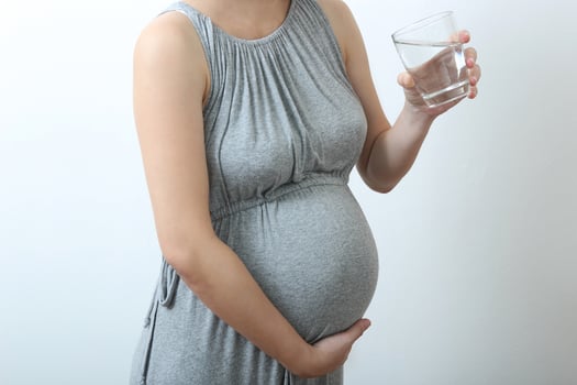 Pregnant woman drinking some water photo