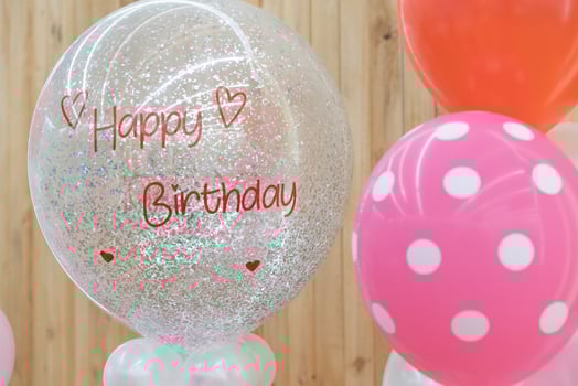 a happy birthday text on the balloon for gift in the birthday party standing in front of wood background. photo