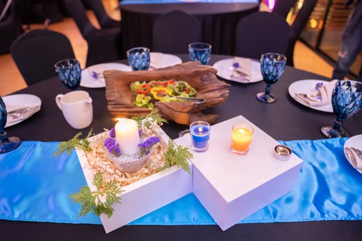 romantic candles are decorated on the dinner table with square white wood box and little tree on it. photo