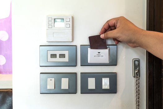 close up hand insert secue card to the into the resort hotel bedroom electric control platform near by the smart lock door in front of the room photo