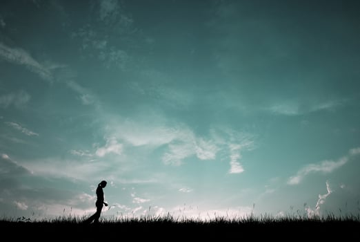 Silhouette of young woman walking with blue sky photo