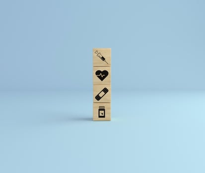 Wooden cube block tower with healthcare icon syringe, health, pills and band on blue studio background. photo