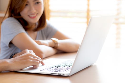 Asian young couple using laptop computer think and searching internet together, man and woman casual smiling work at home with happy and relax, communication and business concept. photo