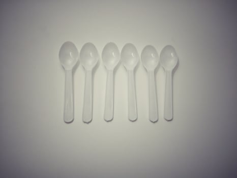 White plastic spoon white background gives the concept of disposable plastic that pollutes the environment.  Affecting global warming photo