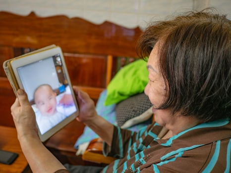 Grandmother use her tablet video conference to talk with her Grandchild photo