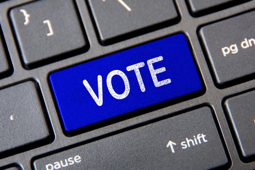 Voting concept - Laptop keyboard with blue Vote button. photo