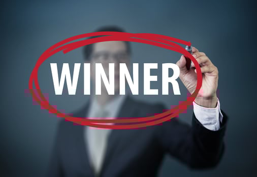 Businessman hand writing WINNER with red marker on transparent board, new business concept, studio shot photo