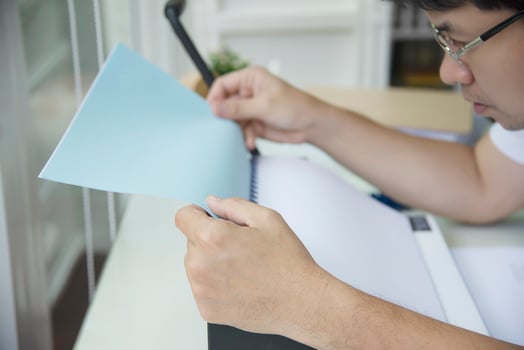 Man making report using comb binding machine - people working with stationary tools concept photo