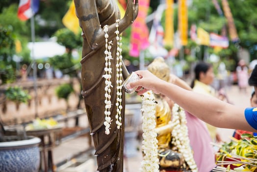 People pouring water onto a Buddha image this is a gesture of worship - people participate the local annual Chiang Mai traditional Bhudist festival. photo