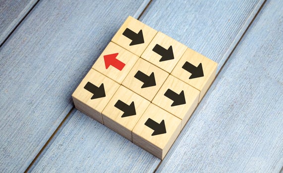 Leadership concept, Red wooden block with arrow icon on blue background. photo