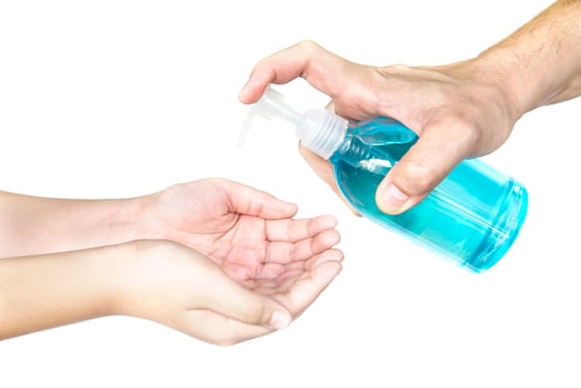 Closeup of father hand pushing alcohol sanitizer gel pump dispenser to son hand isolated over white background - people with alcohol sanitizer prevent bacteria and COVID-19 virus protection concept. photo