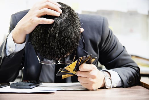 Businessman holding credit cards thinking seriously about payment loan problem - people with personal financial crisis concept photo