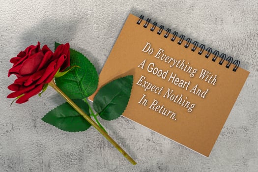 Motivational and inspirational quote on brown note book with red roses. photo